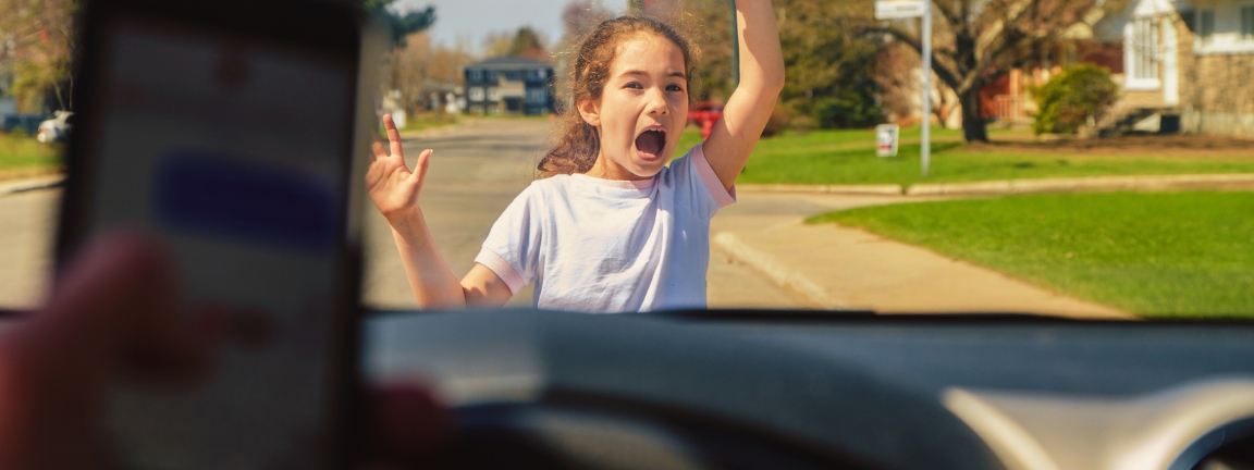 Little girl screaming before being hit by car because driver has cell phone and texting while driving Seen from inside car driver point of view