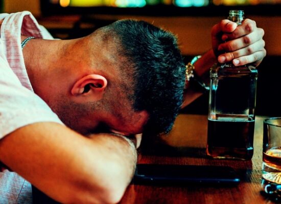 Young caucasian drunk man sleeping on bar counter