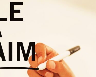 businessman writing "file a claim" on a virtual board