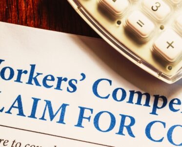 Workers' Compensation form with pen and glasses
