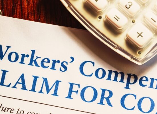 Workers' Compensation form with pen and glasses