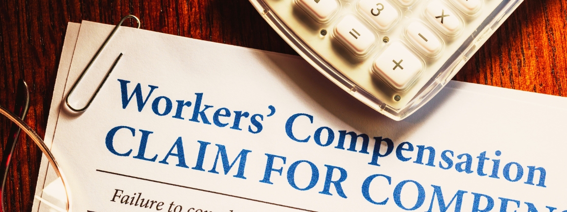 Workers' Compensation form with pen and glasses