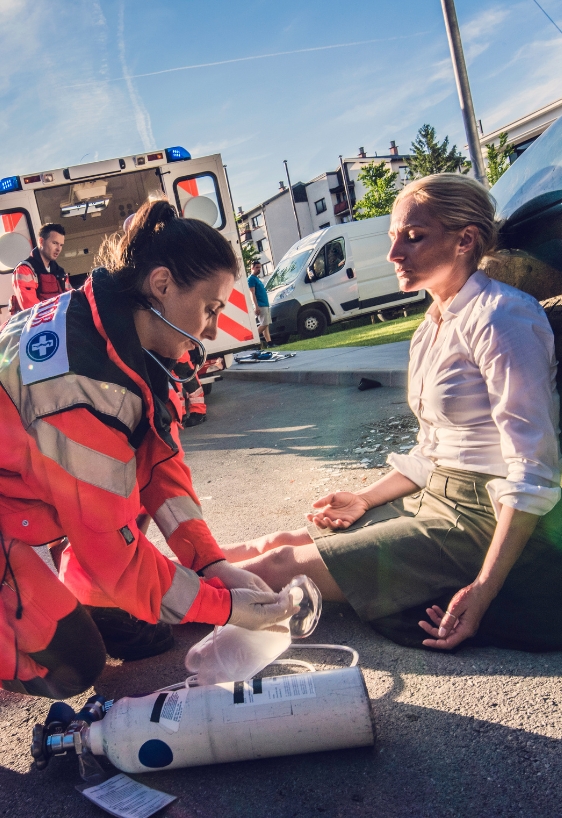 Female doctor providing first aid to woman injured in car accident.