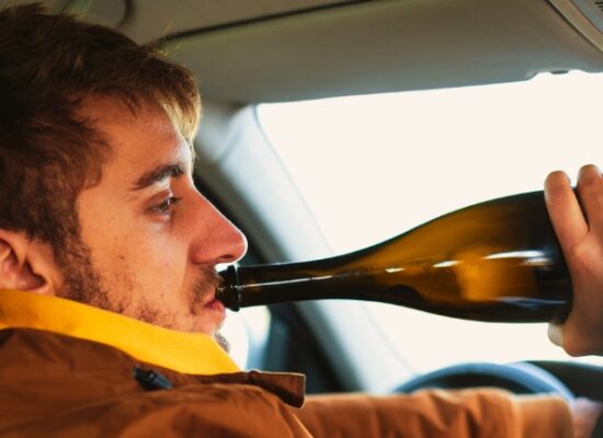 Man drinking alcohol while driving car ,concept drive safely.