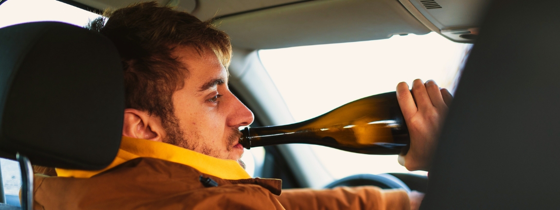 Man drinking alcohol while driving car ,concept drive safely.