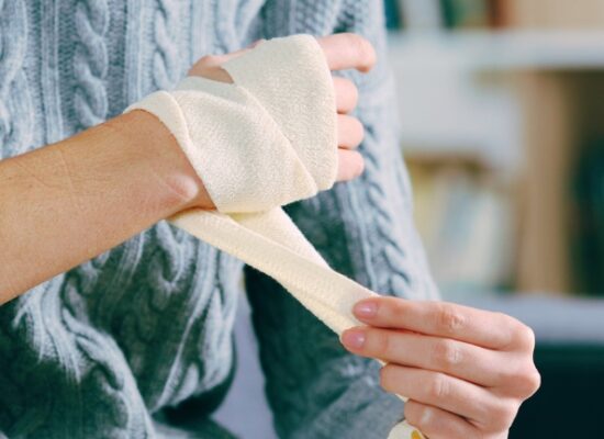 Injured woman hands removing bandage from arm