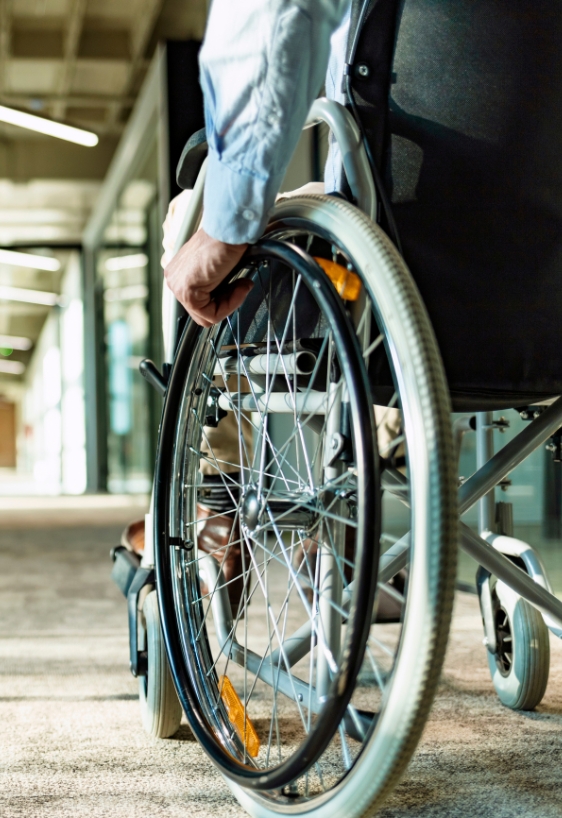 Paralyzed man in a wheelchair on the move in the disabled office building.