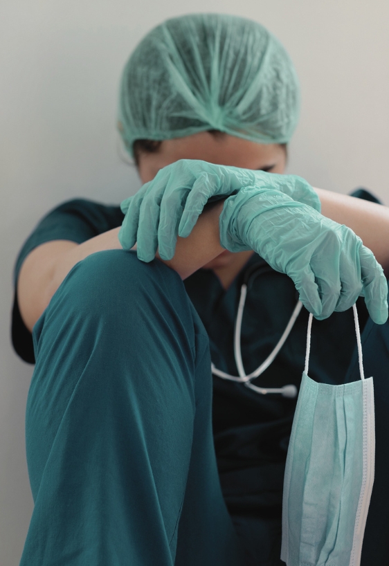 Stressed tired healthcare worker sitting on floor