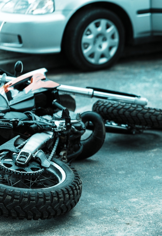 Overturned motorcycle and helmet on the street after collision with the car