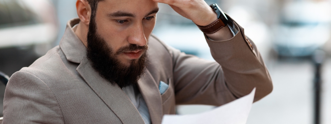 A shocked man reads a court letter.