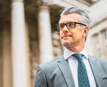 Lawyer walking on the street wearing eyeglasses. Is It Worth Hiring a Personal Injury Lawyer