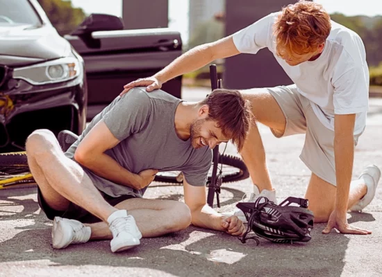 Young man hurt on a bike crash after hit by a car while another young man assisting him. lying about a car accident